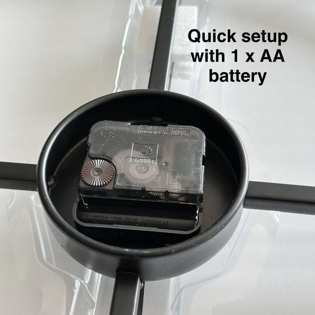 Close-up of battery holder on black metal wall clock.