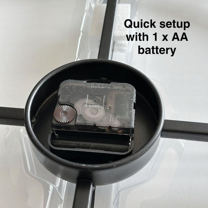 Close-up of battery holder on black metal wall clock.