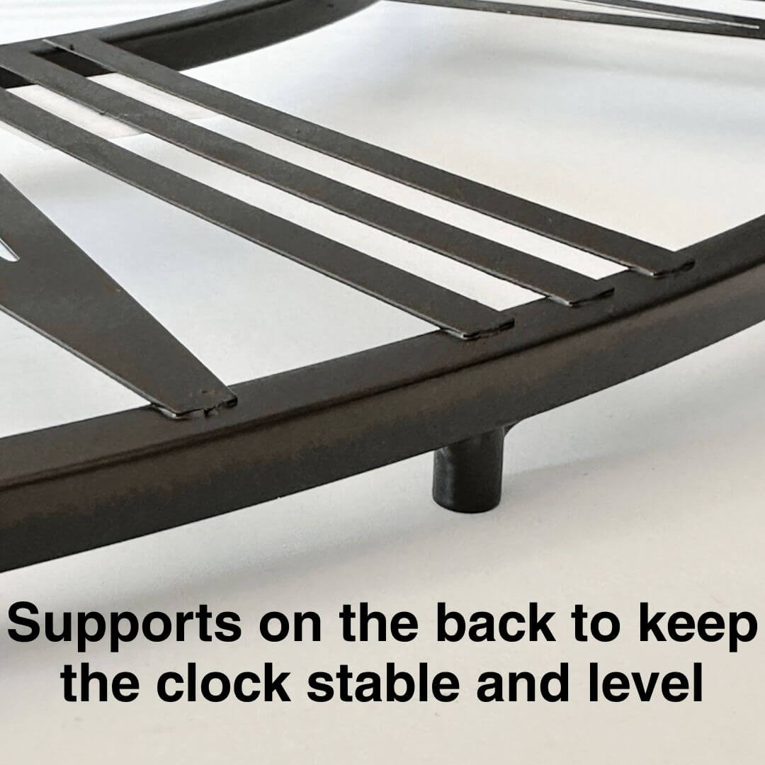 Close-up of black Roman numerals and copper undertone on black metal wall clock