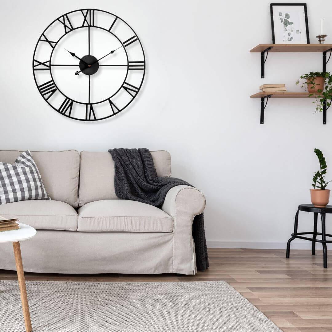 Modern industrial black metal wall clock hanging in living room