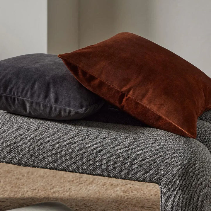 Ava Square Velvet Cushion in 50cm on a grey bench