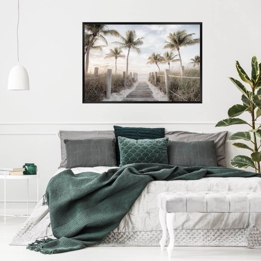 A coastal wall art photo print of a pathway to a beach on the keys Florida with palm trees with a black frame, no border on bedoom wall