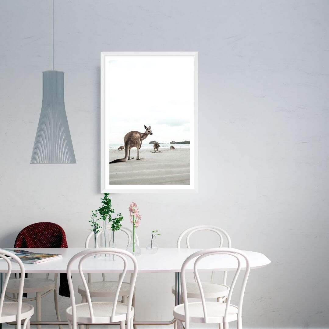 A wall art photo print of beach side kangaroos with a white frame, white border on dining room wall