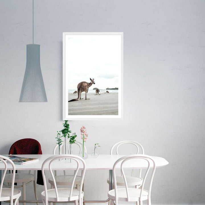 A wall art photo print of beach side kangaroos with a white frame, white border on dining room wall