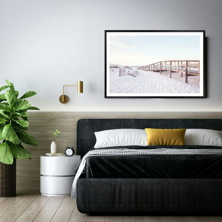 A coastal wall art photo print of a beachside boardwalk with a black frame or unframed to style your bedroom walls