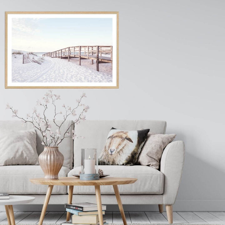 A wall art photo print of a beachside boardwalk with a timber frame or unframed for your coastal living room behind sofa