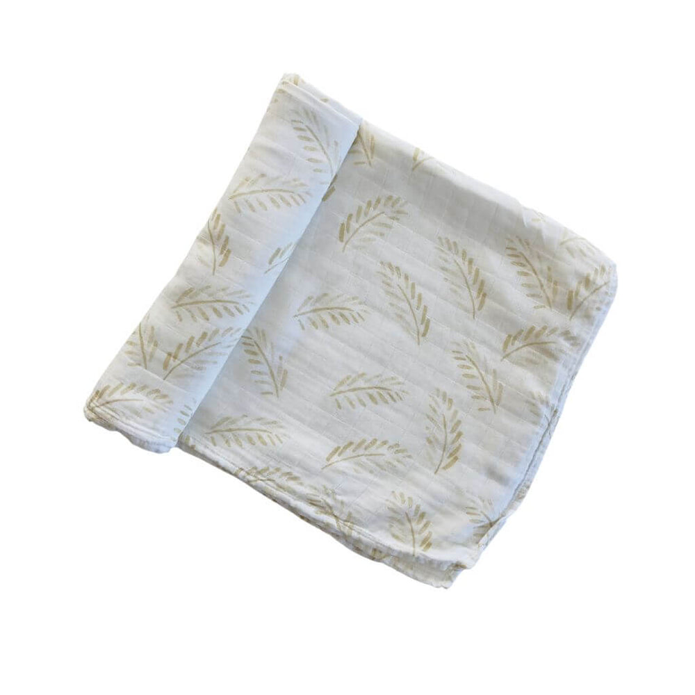 Organic bamboo cotton baby swaddle in Gold Fern print folded neatly on white background
