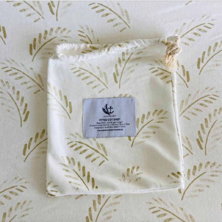 A lightweight Jersey Cotton Fitted Baby Cot Sheet in a natural Gold Fern design.