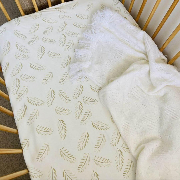 A soft, breathable Jersey Cotton Fitted Baby Cot Sheet in a natural Gold Fern pattern.