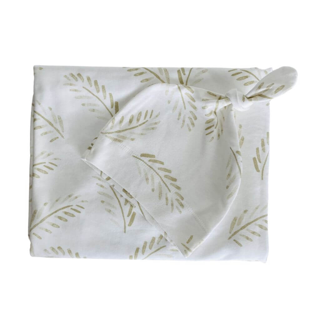 Gold Fern baby swaddle wrap and beanie set in soft cotton – the perfect neutral-toned newborn gift.
