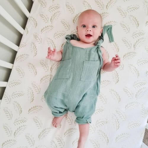 A breathable Jersey Cotton Fitted Baby Cot Sheet in a natural Gold Fern design.