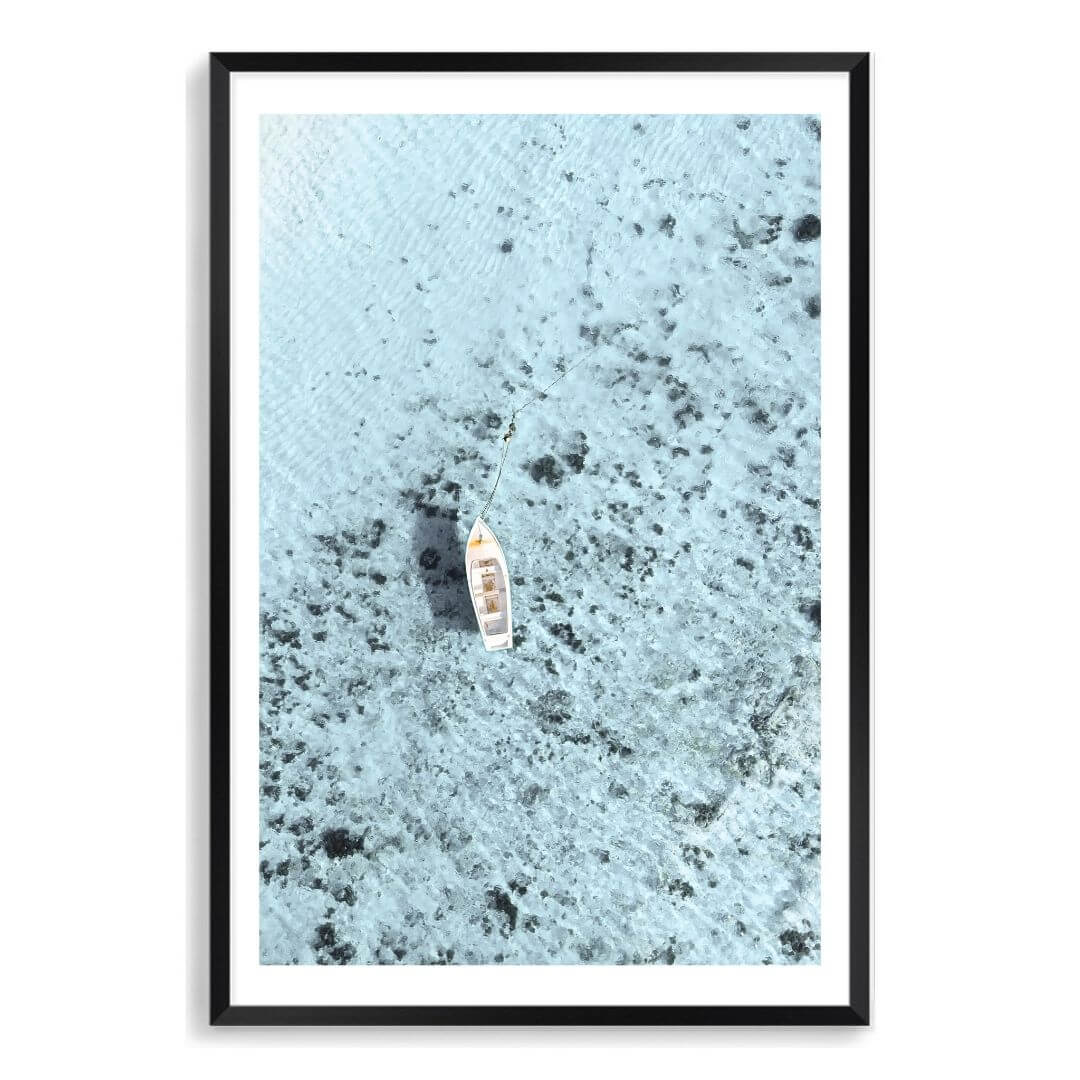 A wall art photo print of a white boat on a clear blue ocean off the Amalfi Coast Italy with a black frame, white border by Beautiful Home Decor