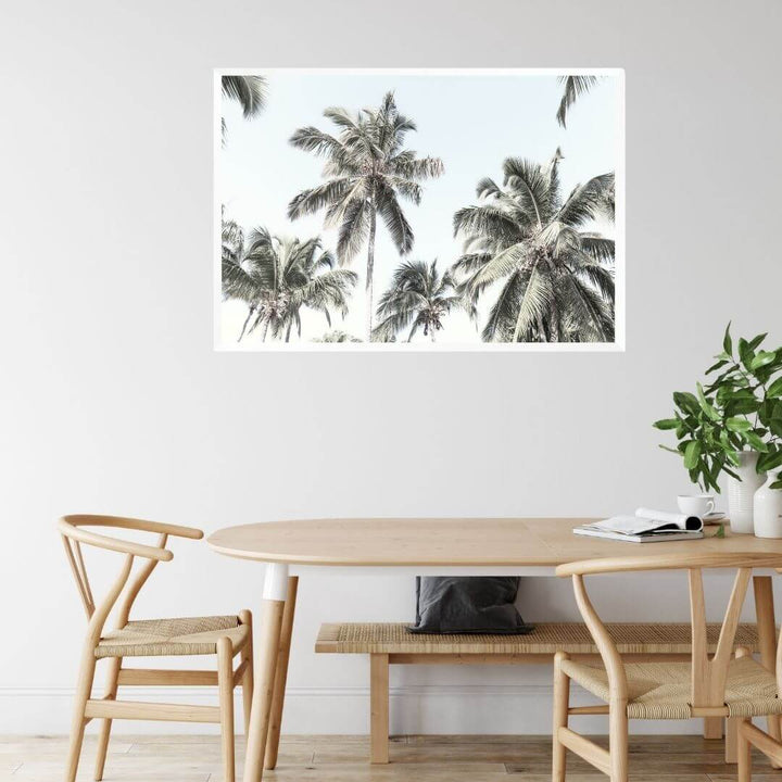 A wall art photo print of coastal palm trees and blue sky with a white frame or unframed to style your dining room walls