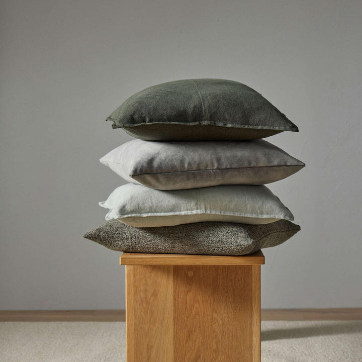 3 Como 50cm 60cm square linen cushions and a boucle cushion on a  timber stool