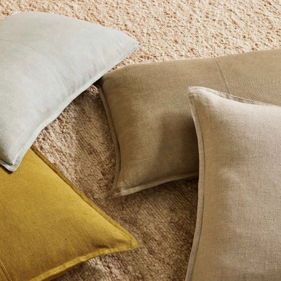 3 Como Rectangle linen cushions and 1 square linen cushion on a rug
