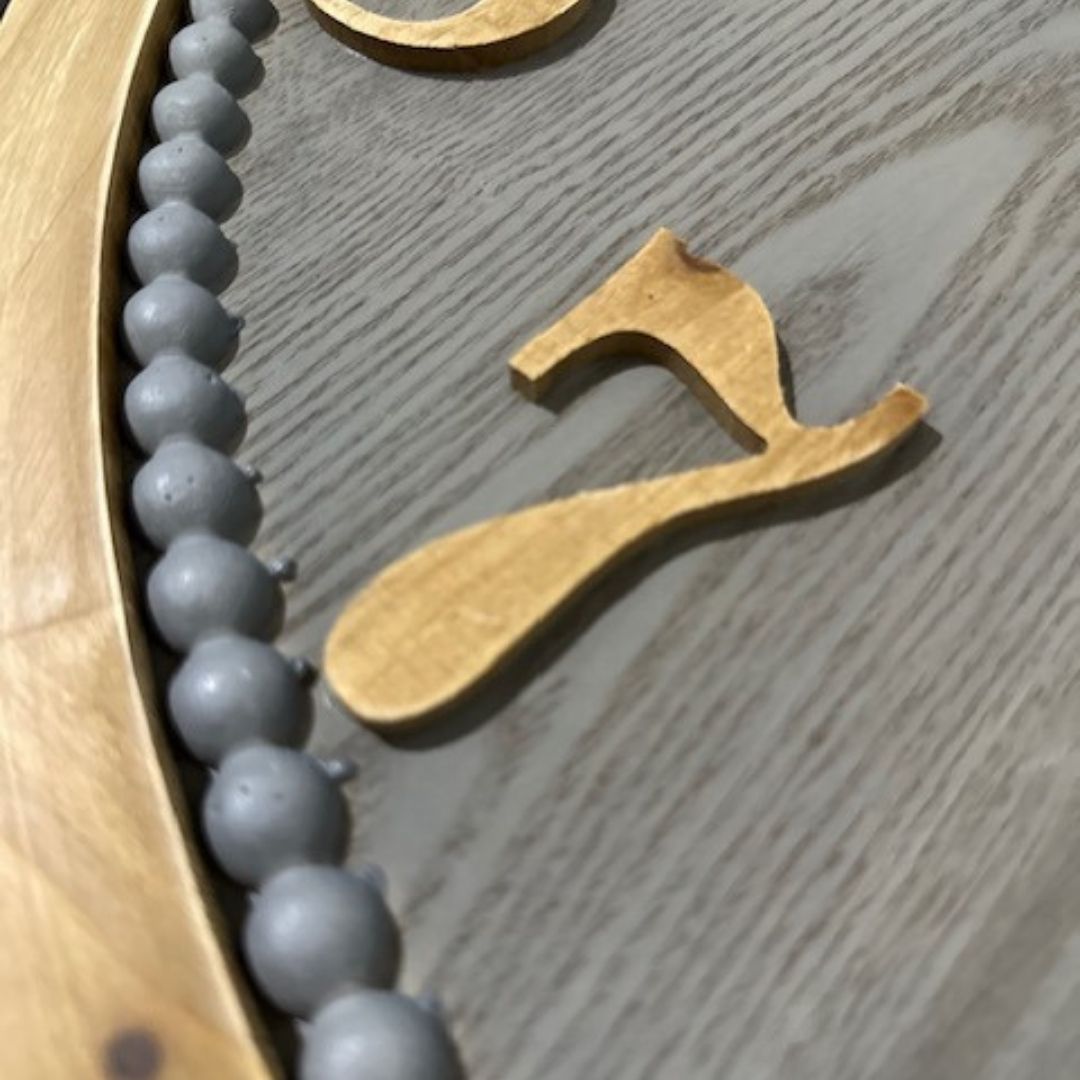 A closeup view of the numbers on the large Contemporary Grey Wall Clock measuring 60cm with timber numbers.