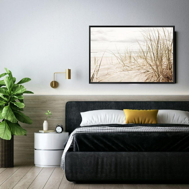 A wall art photo print of a grassy beach shore with a black frame or unframed for the wall above your bedroom bed