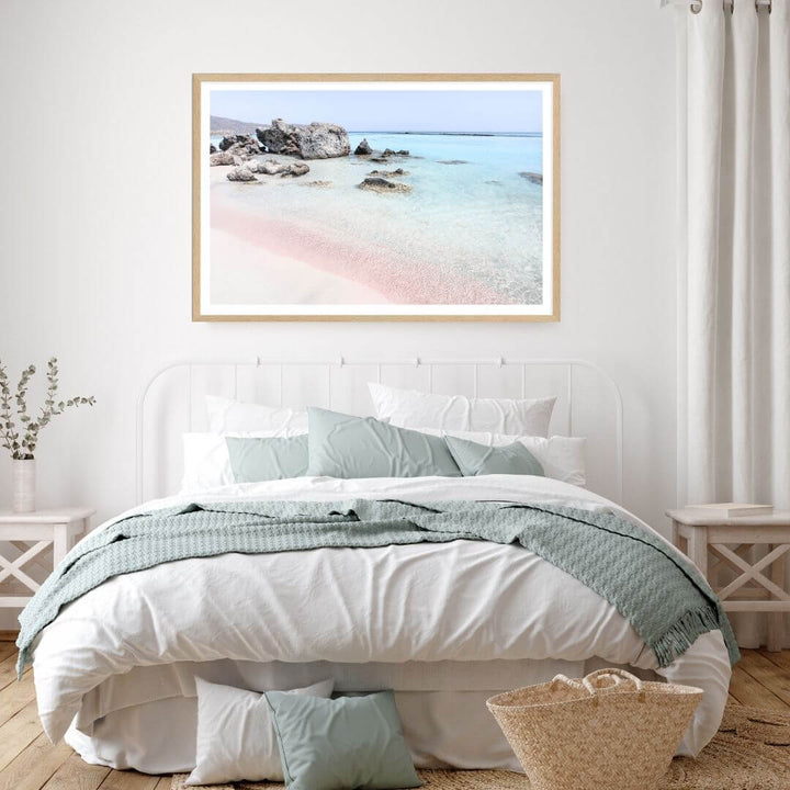 A coastal wall art photo print of a pink beach in Greece with a timber frame to style a coastal Australian bedroom