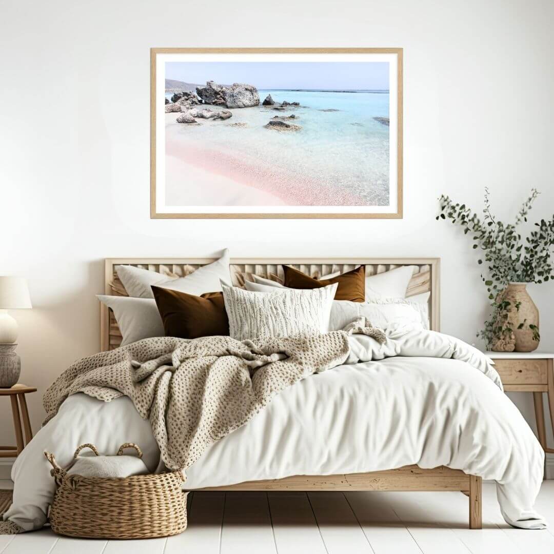 A coastal wall art photo print of a pink beach in Greece with a timber frame or unframed for the wall above your bedroom bed