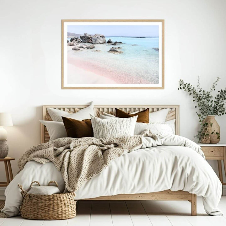 A coastal wall art photo print of a pink beach in Greece with a timber frame or unframed for the wall above your bedroom bed