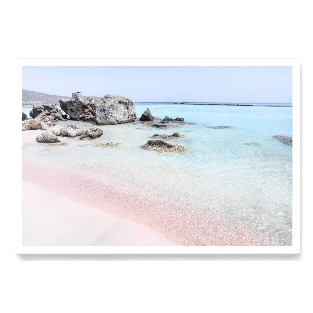 A coastal wall art photo print of a pink beach in Greece unframed with a white border by Beautiful Home Decor