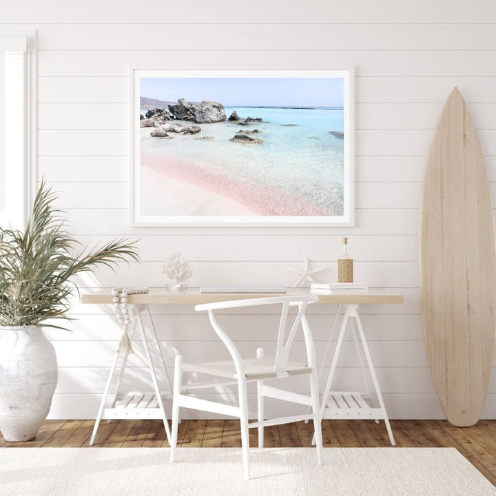 A coastal wall art photo print of a pink beach in Greece with a white frame or unframed to decorate an empty wall