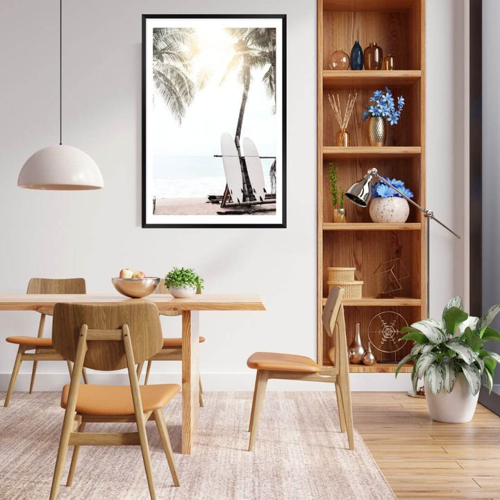 A wall art print in the dining room of two surf boards under the palm trees on a surfer beach in Hawaii