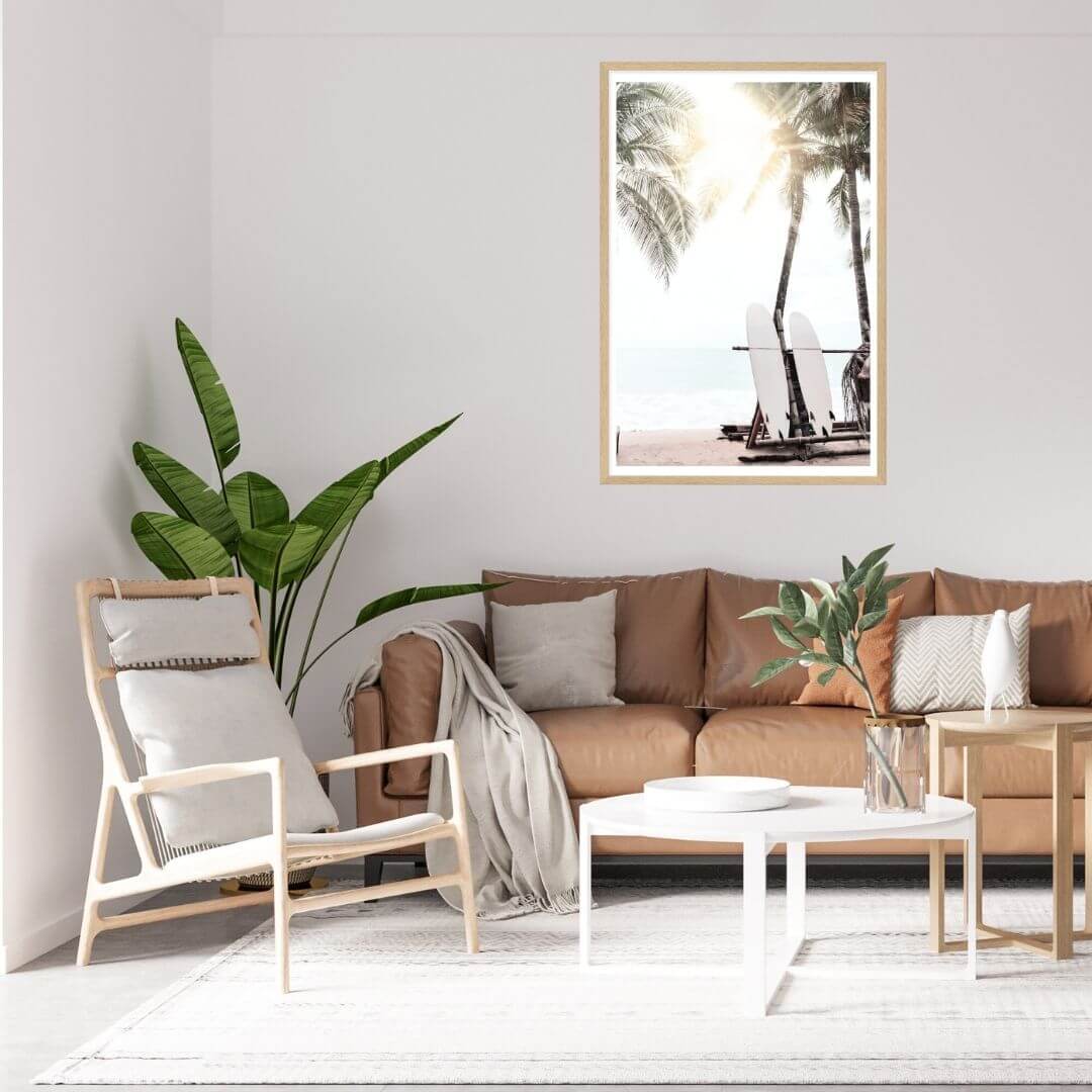 A wall art print of two white surfboards on a surfer beach in Hawaii under the palm trees with a sunset view. with a timber frame
