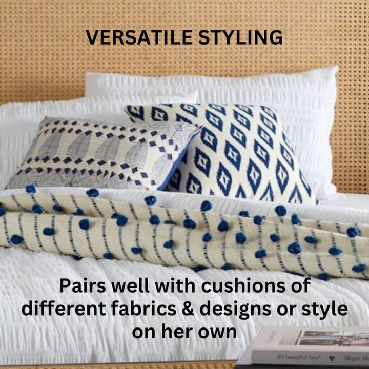 Styled on a bed alongside other cushions is the Hamptons Blue and White Cushion with a geometric shape