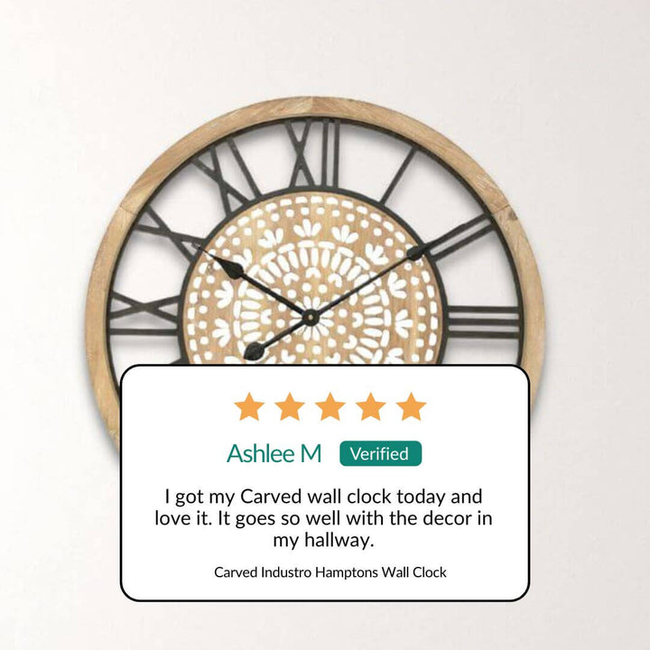 Carved wall clock with a five-star review from Ashlee M on a light background