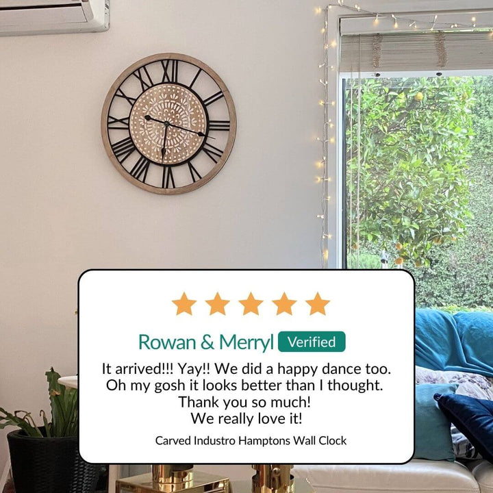 Living room with a carved industrial Hamptons wall clock, decorative lights, and a five-star review from Rowan & Merry.