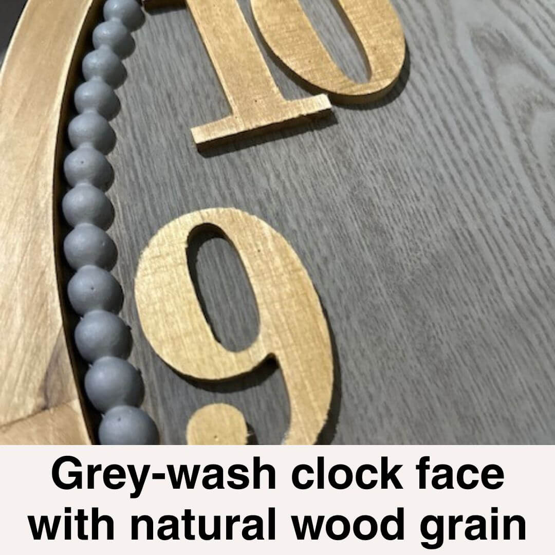 Close-up of a clock face with grey-wash and natural wood grain design.