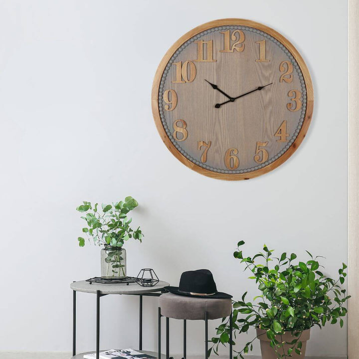 60cm Contemporary Grey Timber Wall Clock on a white wall with a small table and plants below.