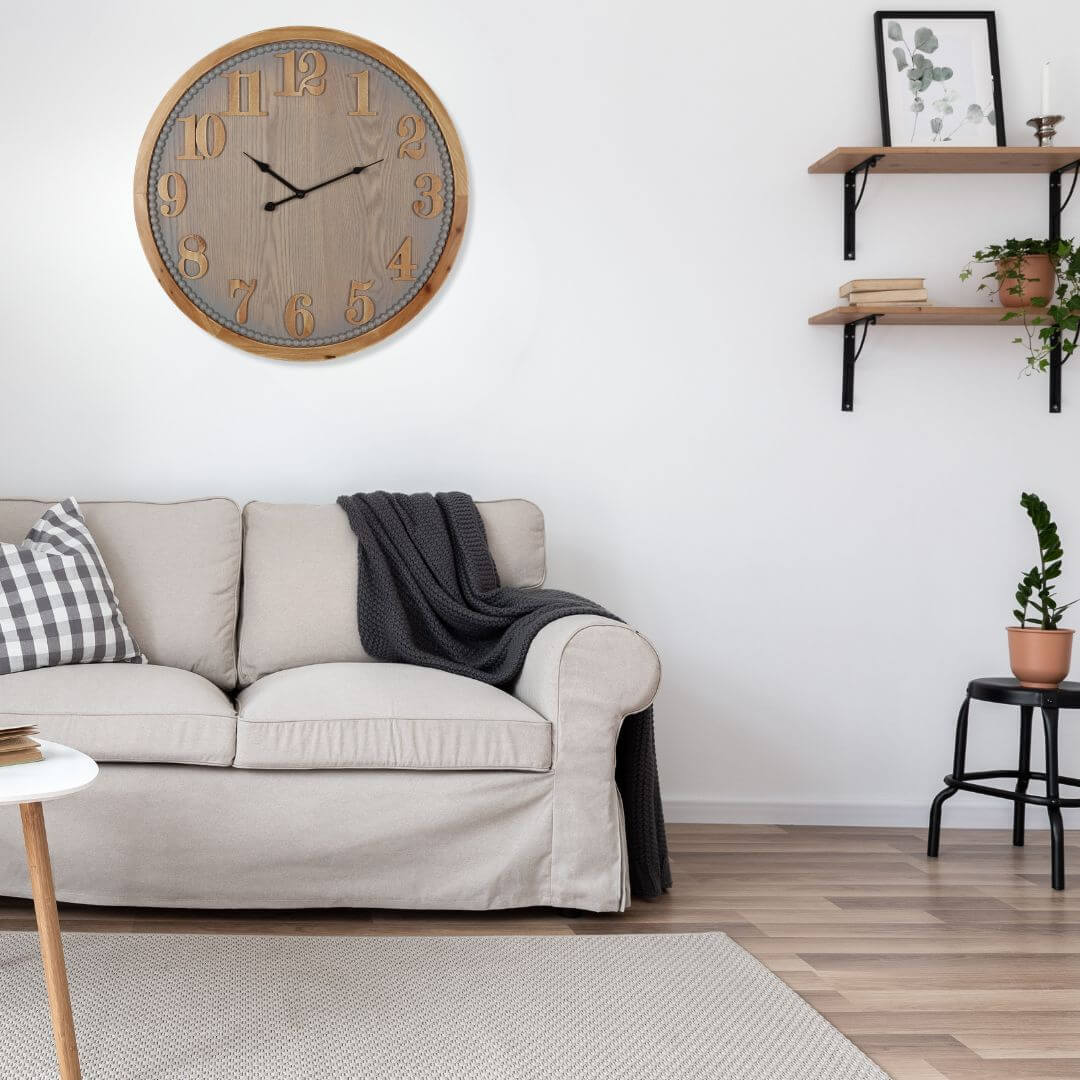 60cm Contemporary Grey Timber Wall Clock in a living room with sofa and shelves
