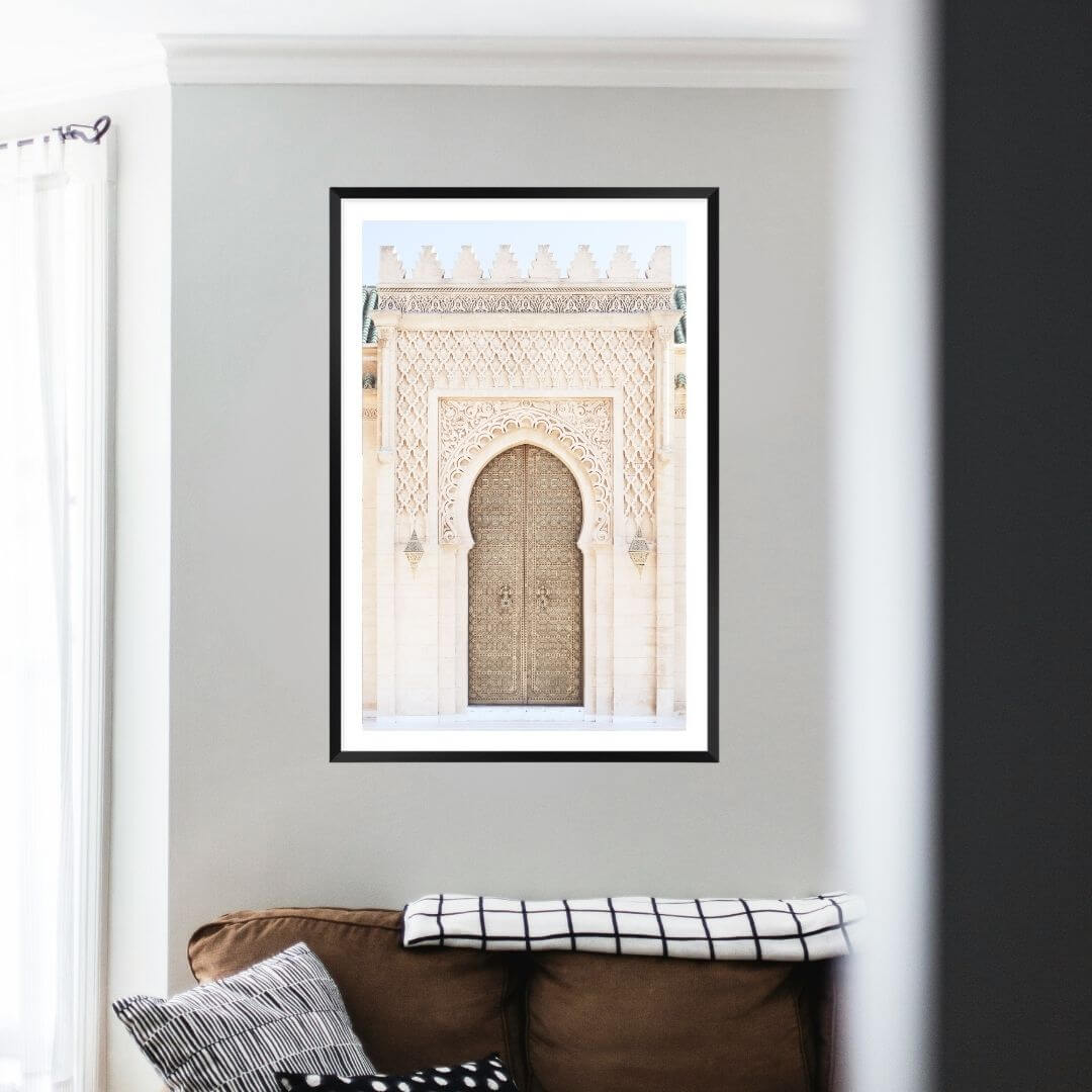 A wall art photo print of a Moroccan Temple Door with a black frame on a wall above a sofa by Beautiful HomeDecor