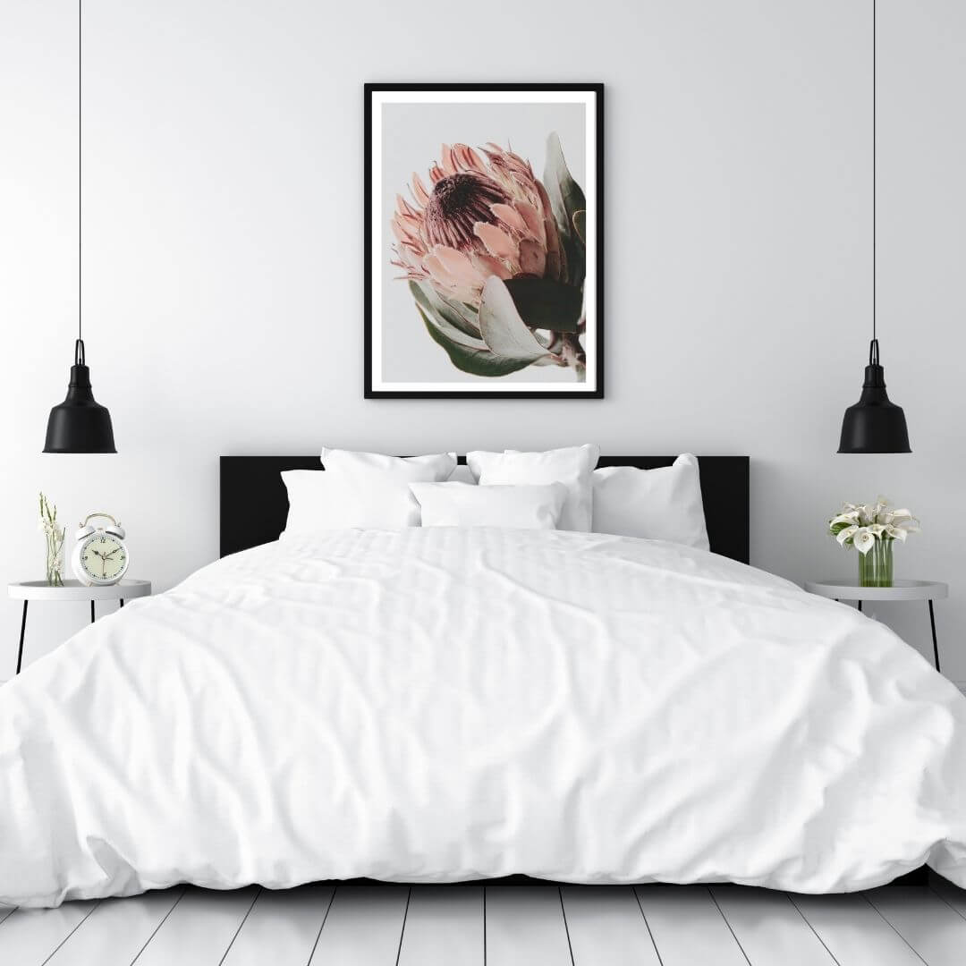 A wall art photo print of a peach protea floral a with a black frame to decorate your bedroom walls