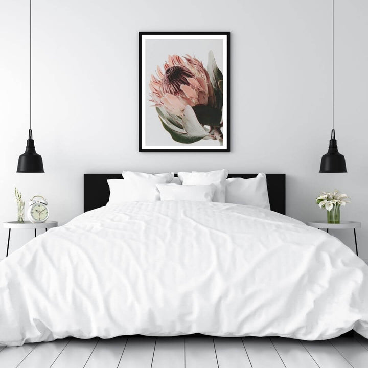 A wall art photo print of a peach protea floral a with a black frame to decorate your bedroom walls