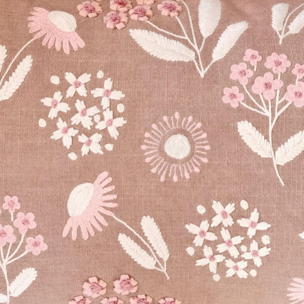 A close up view of the Posy Embroidered Floral Cushion in Warm Taupe, pink and cream, 35cm x 55cm rectangle, perfect to style your bedroom or living room.