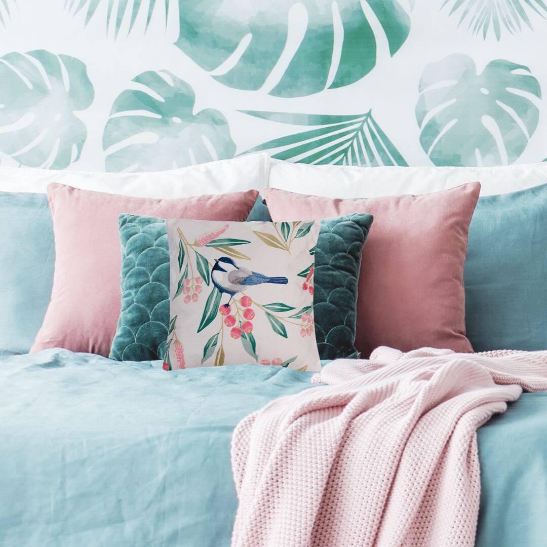 Pretty Bird Cushion on a bed with pink and green cushions