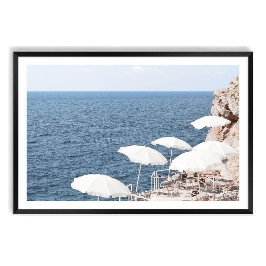 A wall art photo print of white umbrellas on an Amalffi Coast Beach Italy with a black frame, white border by Beautiful Home Decor