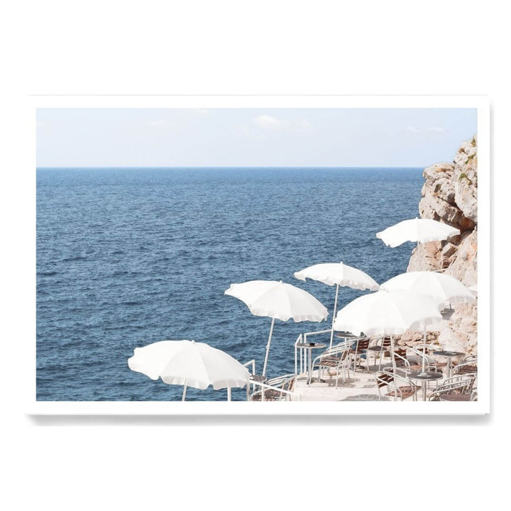 A coastal wall art photo print of white umbrellas on an Amalfi Coast Beach Italy unframed with a white border by Beautiful Home Decor
