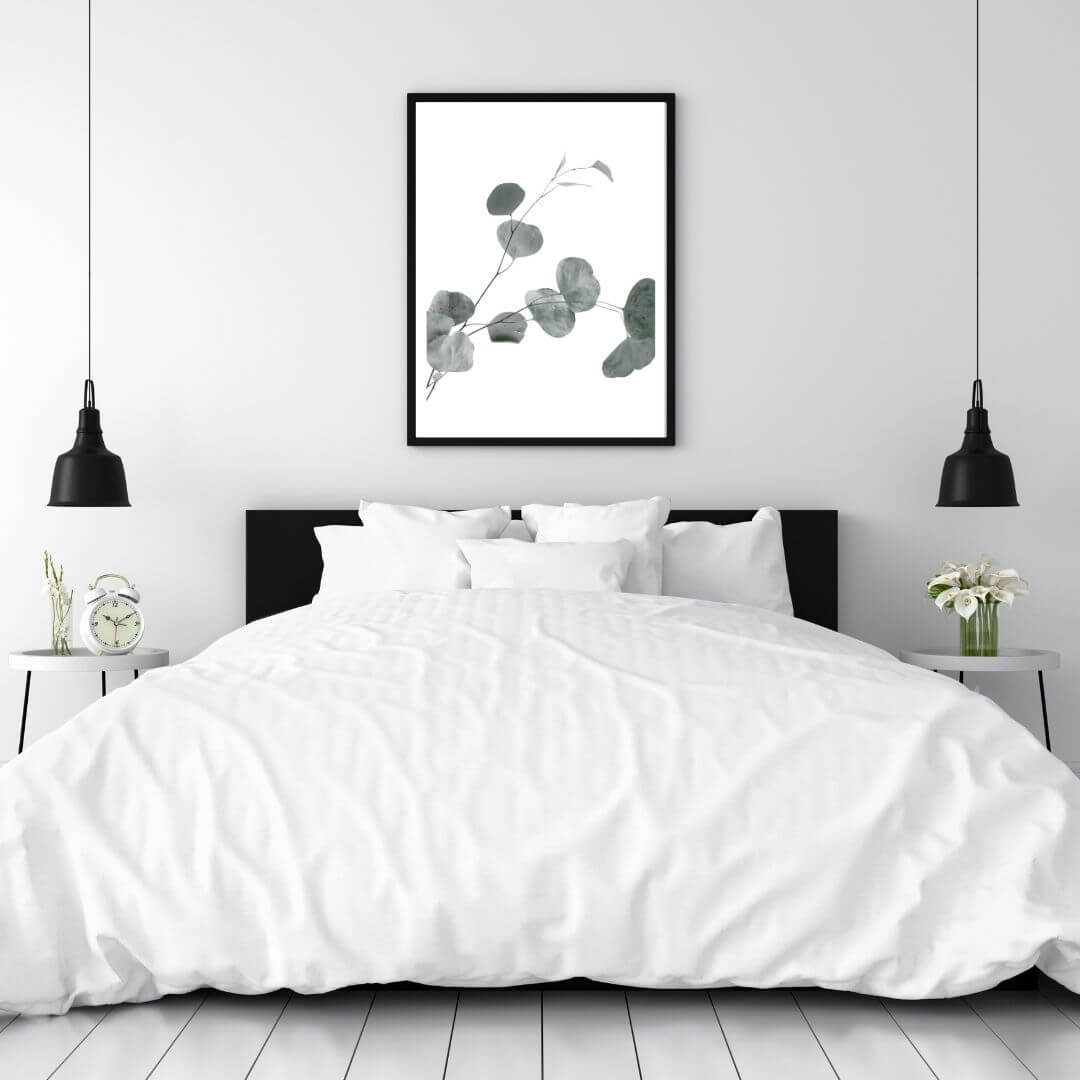 A wall art photo print of an Australian native eucalyptus leaves B with a black frame to style a wall in a bedroom