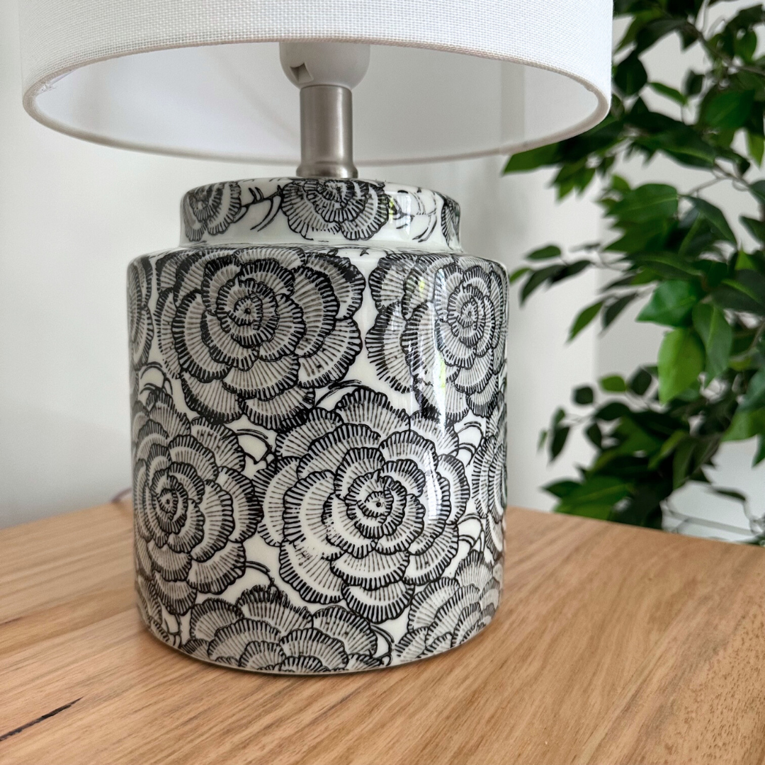 The beautiful Camelia Table Lamp has a black and white ceramic base with a floral design and white fabric shade, Suits contemporary, mid-century or industrial interior design styles.