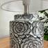 The stylish Camelia Table Lamp has a black and white ceramic base with a floral design and white fabric shade, Suits contemporary, mid-century or industrial interior design styles.