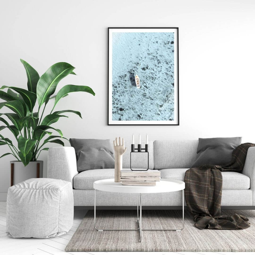 A wall art photo print of a white boat on a clear blue ocean off the Amalfi Coast Italy with a black frame, no border on bedoom wall