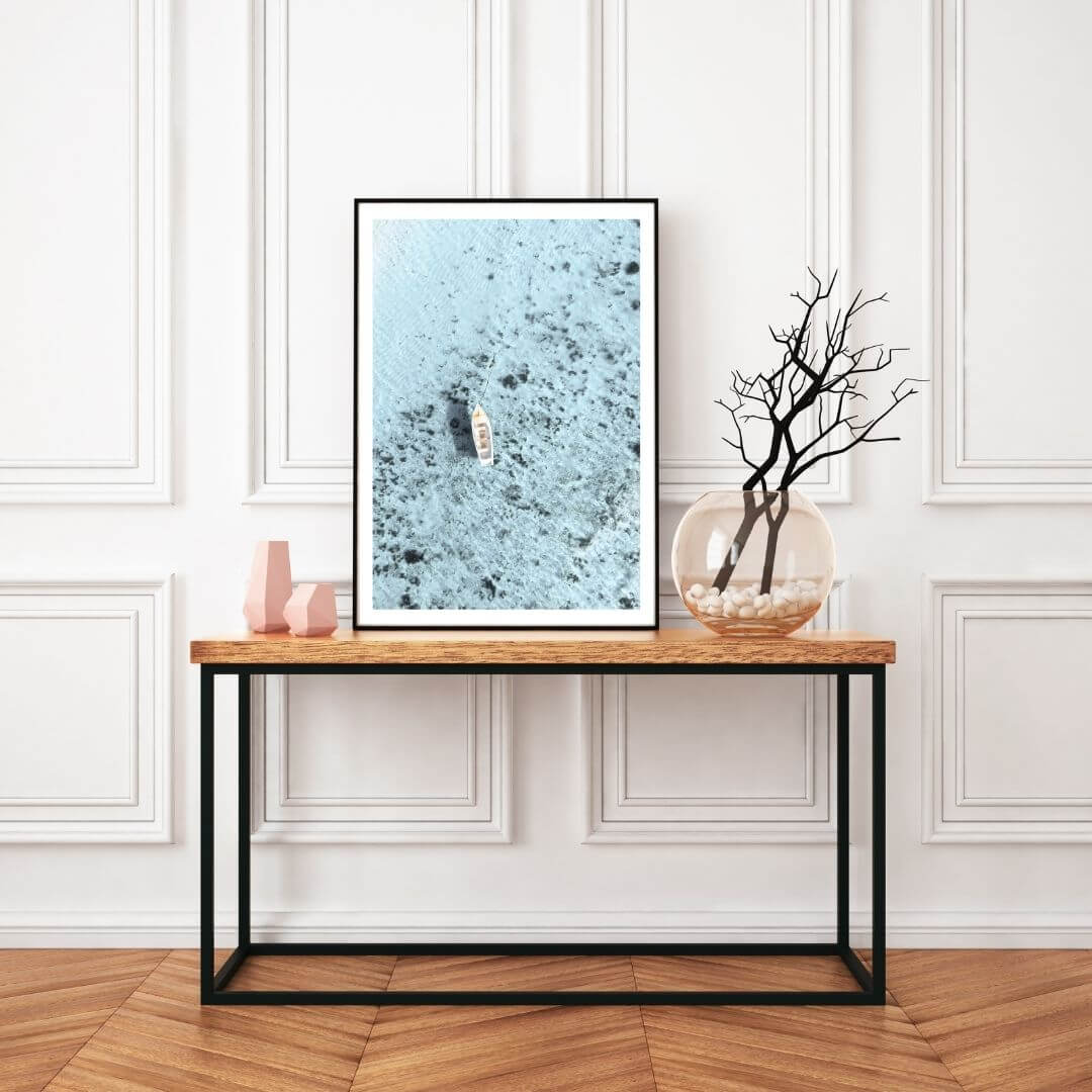 A wall art photo print of a white boat on a clear blue ocean off the Amalfi Coast Italy with a frame in black to style a wall in your hallway