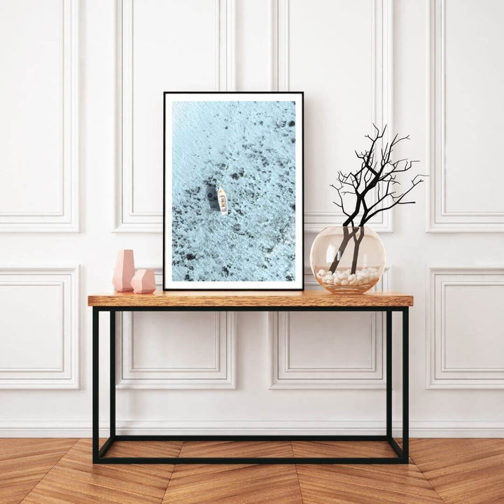 A wall art photo print of a white boat on a clear blue ocean off the Amalfi Coast Italy with a frame in black to style a wall in your hallway