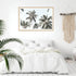 A wall art photo print of coastal palm trees and blue sky with a timber frame to style a coastal Australian bedroom