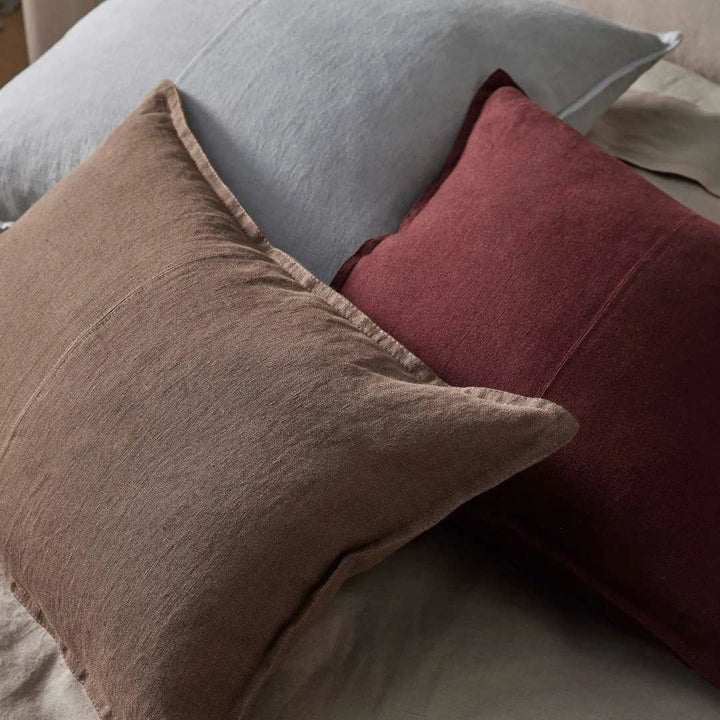 Closeup of 3 Como Linen Cushions in red, brown and grey.