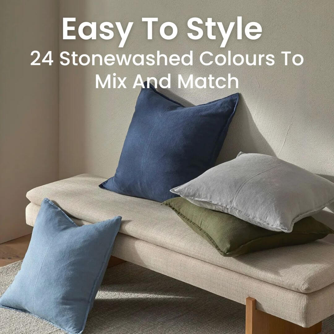 Como 50cm and 60cm square linen cushions in stonewashed blue, green and grey on a bench.